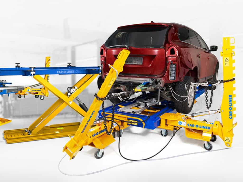 Automobil på reparationsbænk med værktøj og udstyr.